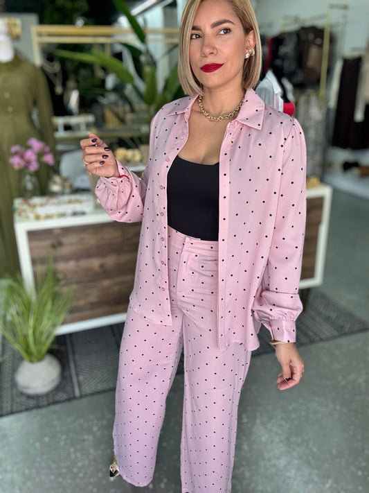 Black scoop-neck sleeveless bodysuit, worn under pink button-up shirt.