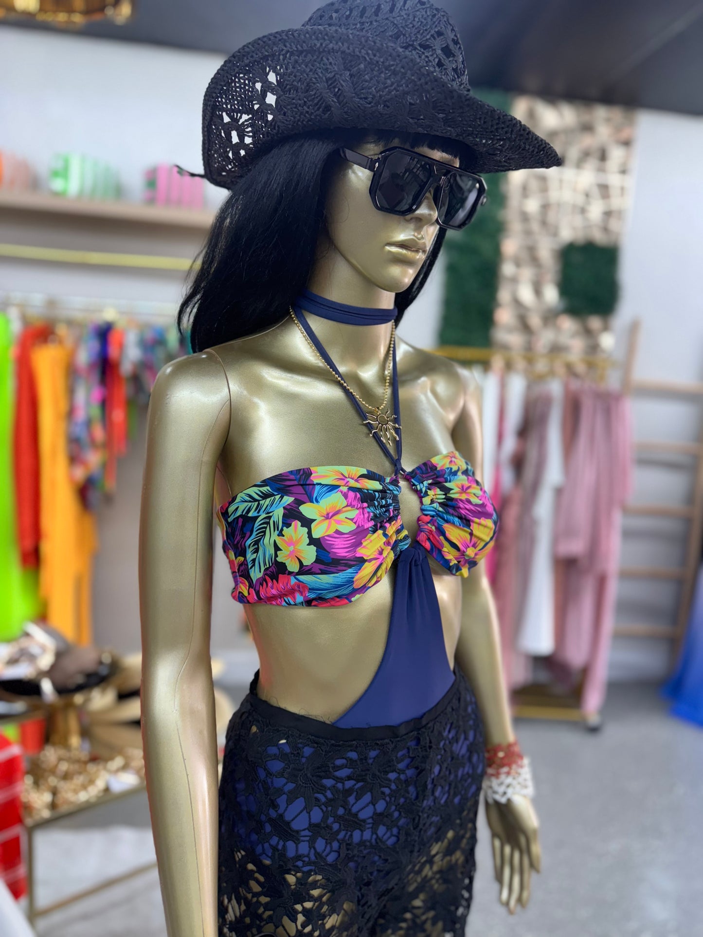 Black crochet beach hat with wide brim and perforated pattern, worn with sunglasses