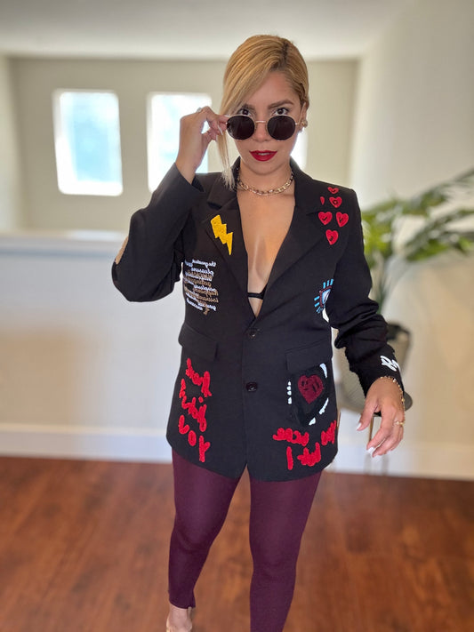 Black blazer with colorful patchwork hearts, lightning, and eye motifs