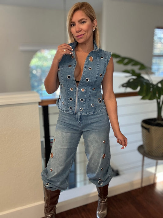 Light blue denim eyelet vest and jeans with metal ring eyelets on seams.