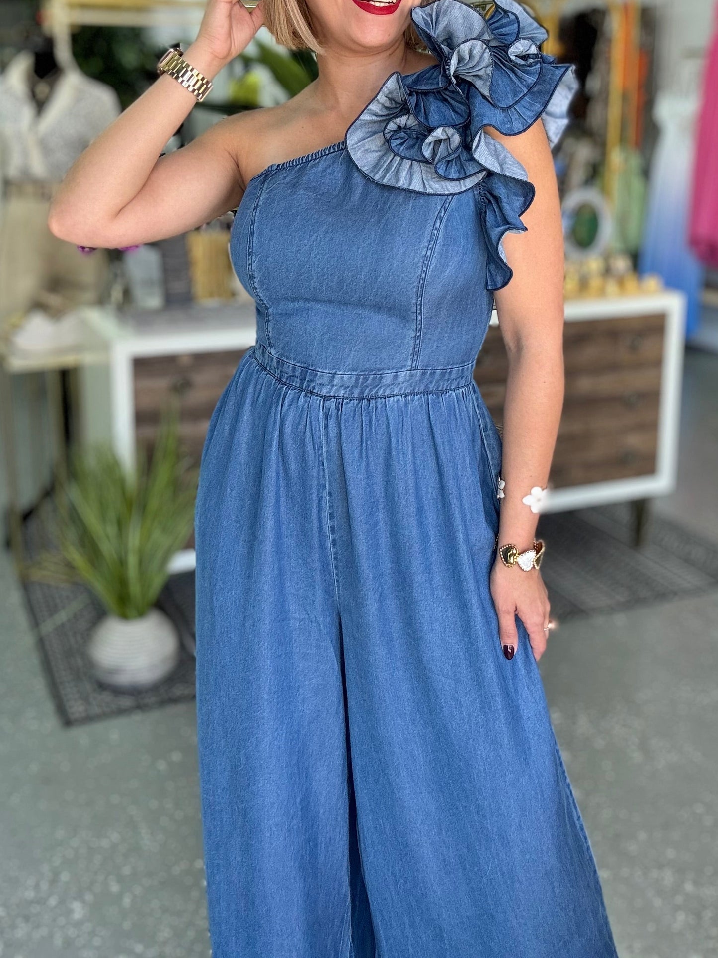 Blue denim one-shoulder jumpsuit with ruffled shoulder and elasticized gathered waist