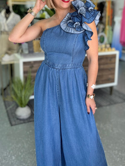 Blue denim one-shoulder jumpsuit with ruffled shoulder and elasticized gathered waist