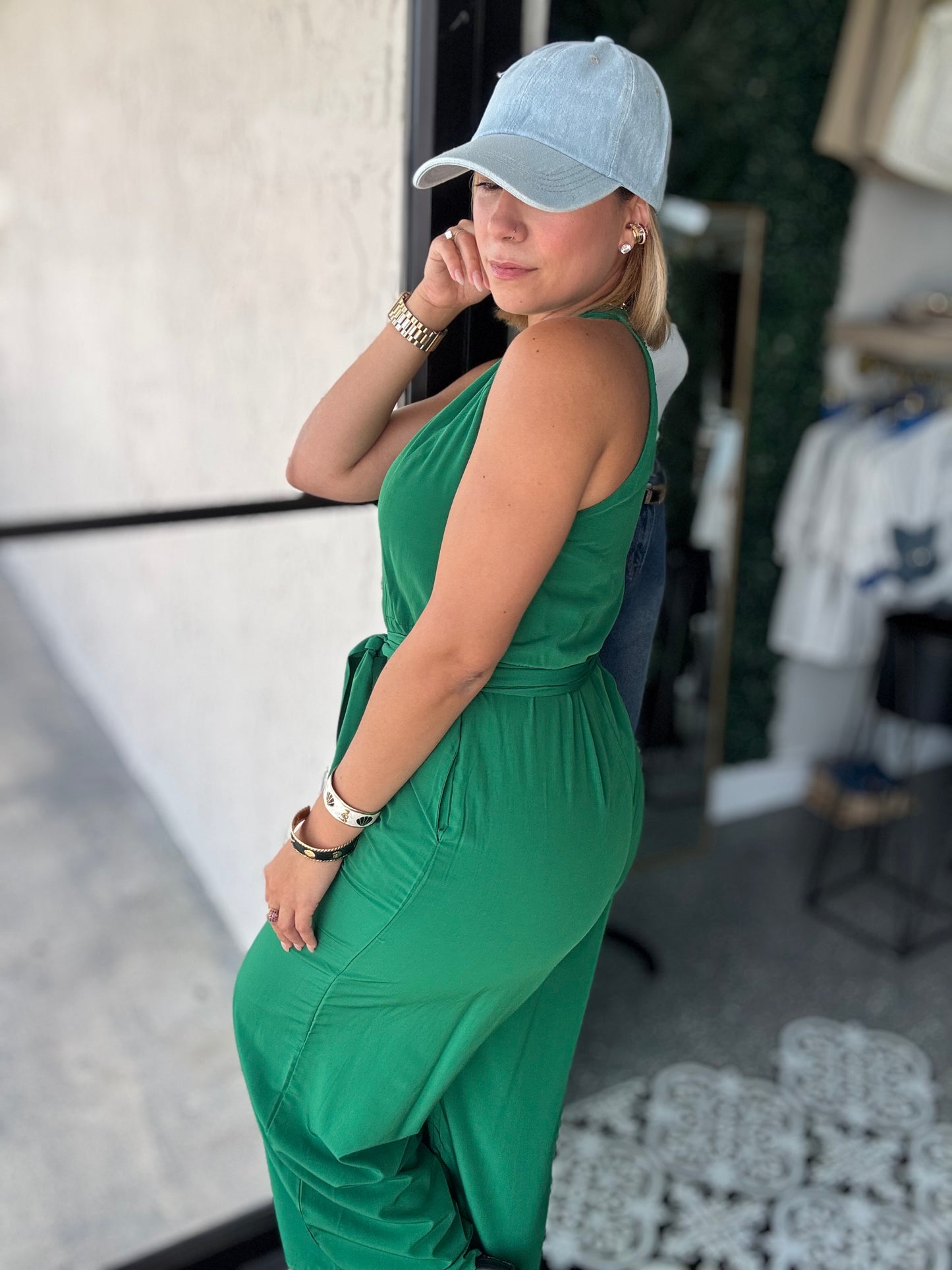 Emerald green sleeveless jumpsuit, side view, with tie waist and button placket