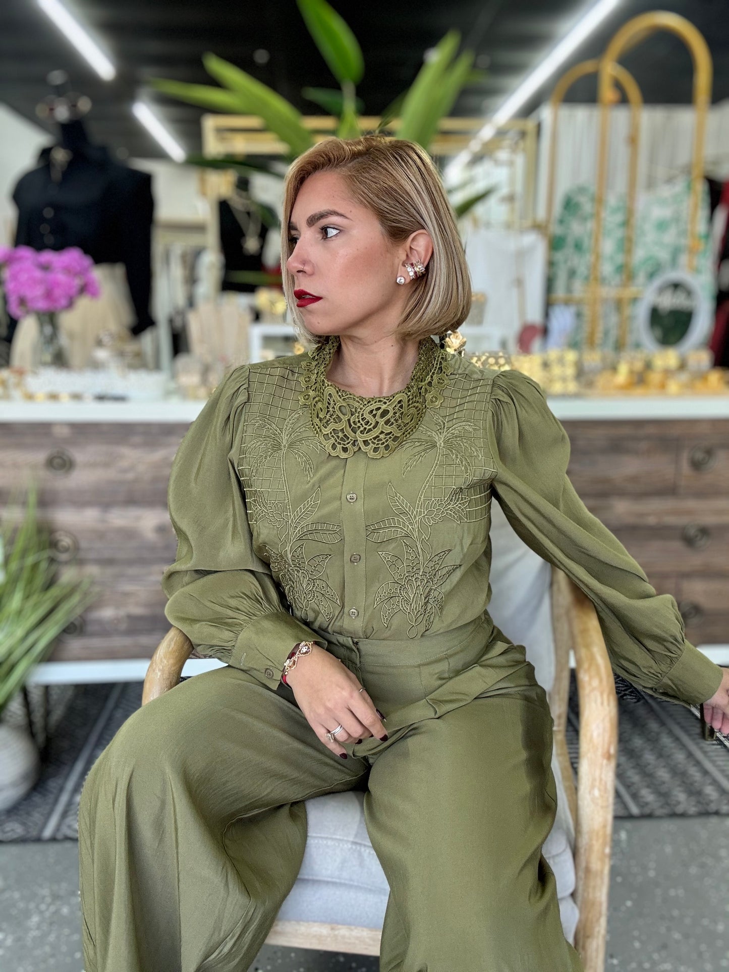 Olive green blouse and wide-leg pants set with lace yoke, seated side view
