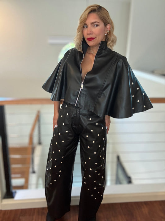 Black leather-style zip jacket with flared sleeves and studded wide-leg pants, 3/4 view