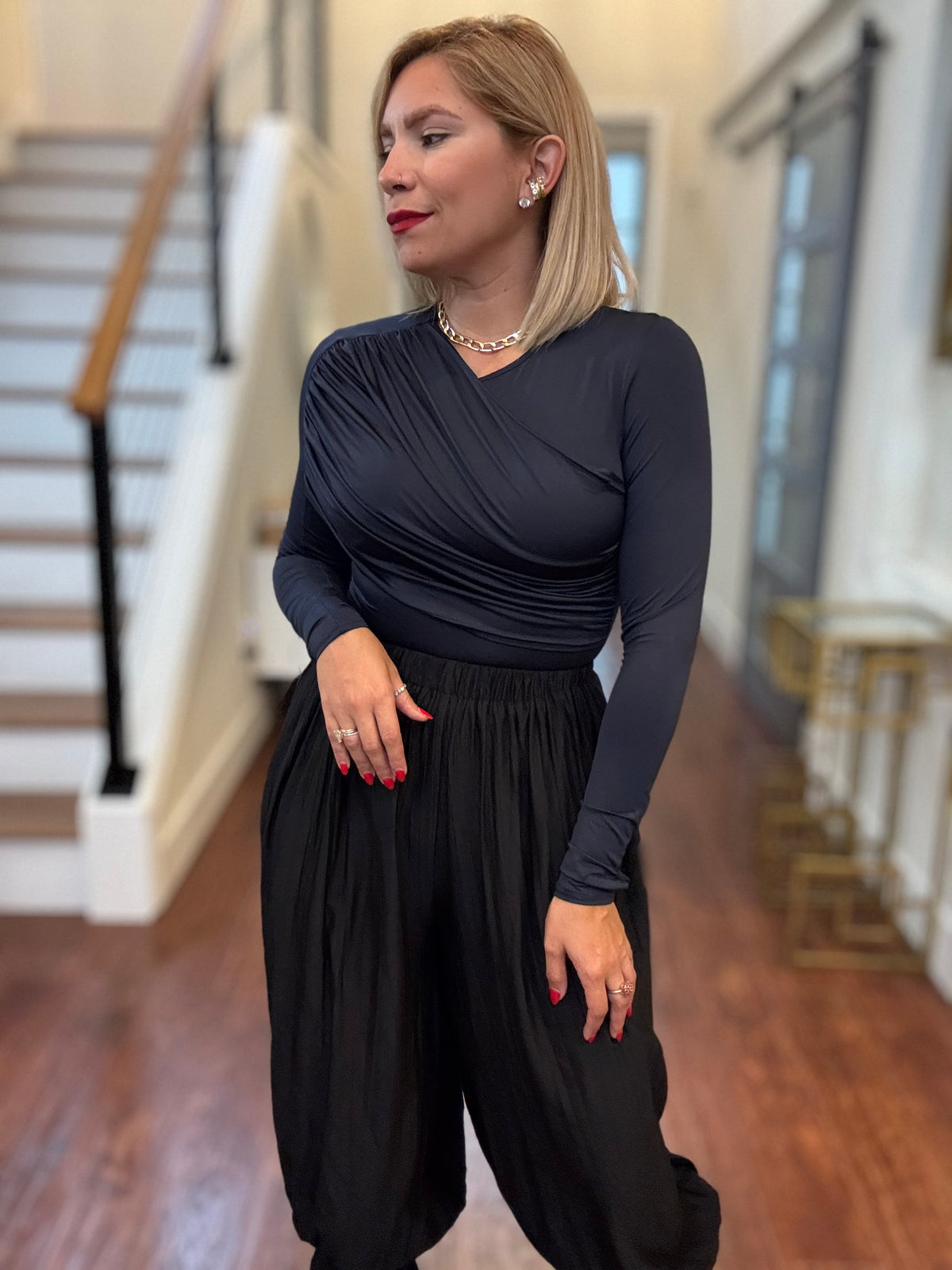 Dark blue long-sleeve bodysuit with gathered waist detail and V-neck wrap design