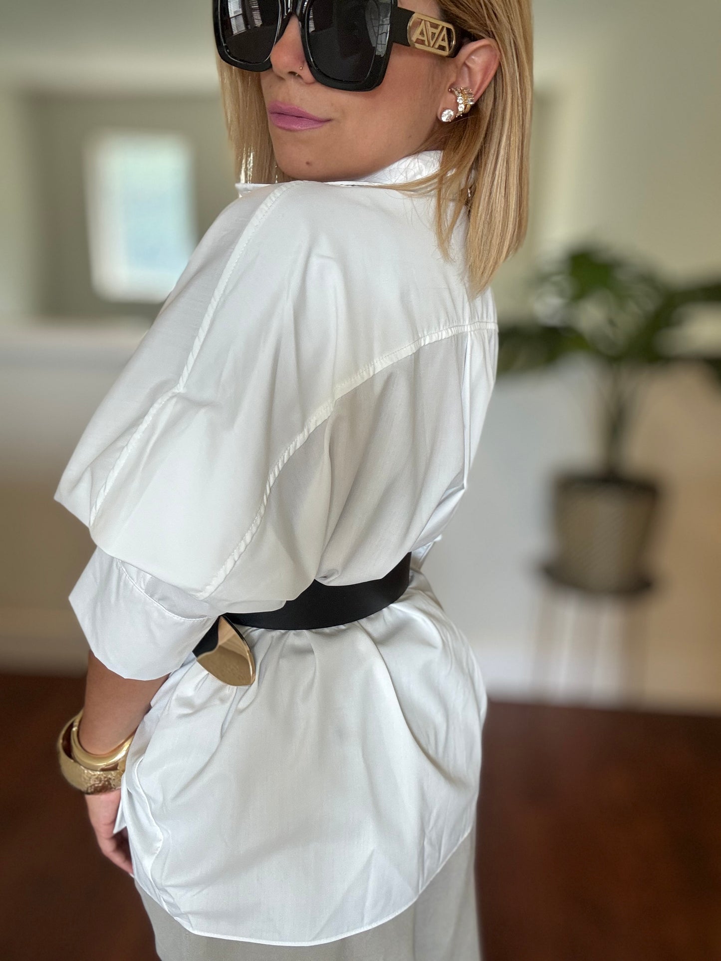 White button-up peplum top with side drape, gathered shoulder, and layered hem