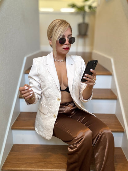 Ivory textured blazer with notch lapels, front pockets, and gold button closure