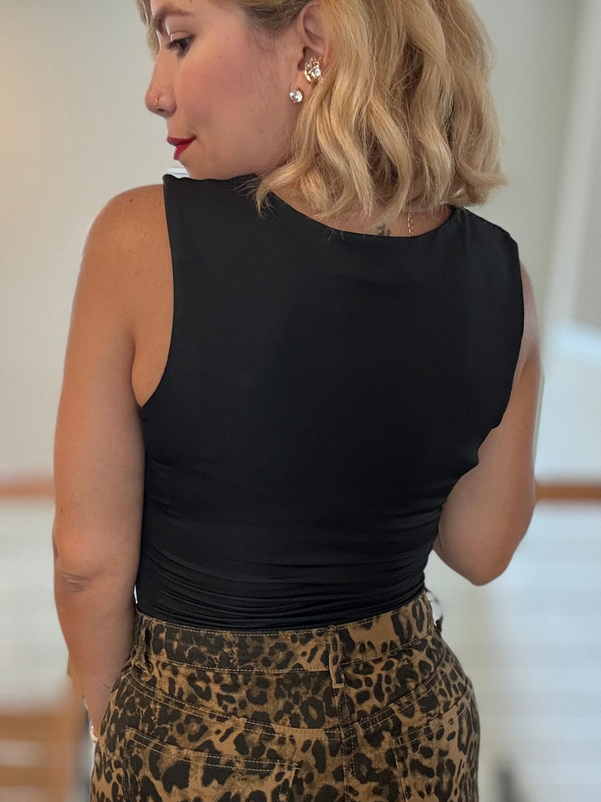 Black sleeveless bodysuit, back view with high neckline and open back cutout