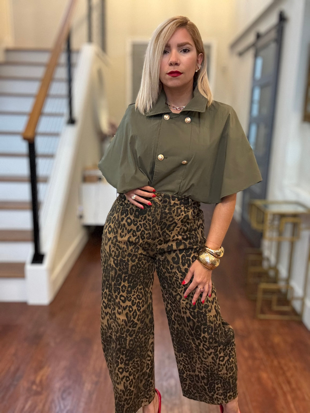 Olive green cape-style top with short sleeves, double-breast buttons, and pointed collar