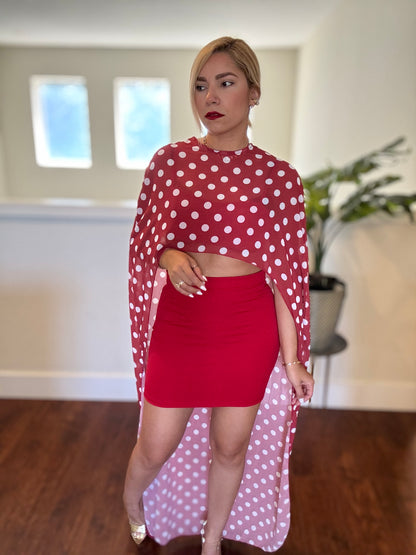 Red two-piece set with polka-dot sheer wrap and bandeau crop top above mini skirt.