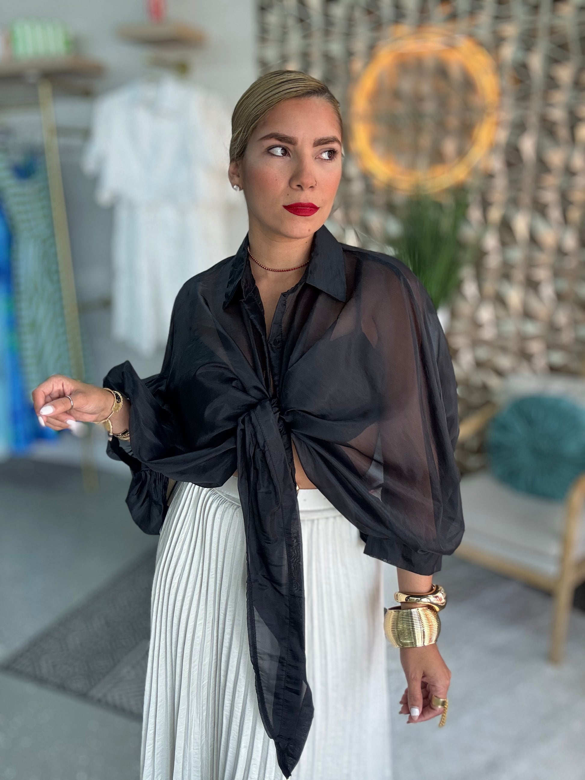 Black sheer button-front blouse with tie waist detail and long puff sleeves