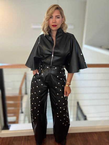 Black leather-style jacket with zipper and flared sleeves, plus studded wide-leg pants