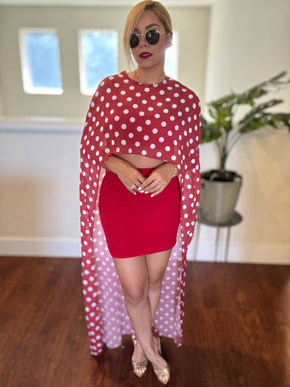 Red crop top and mini skirt with white polka-dot sheer wrap flowing to the floor.