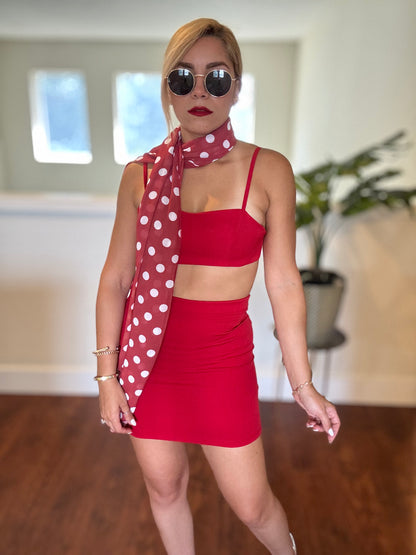 Red two-piece outfit with polka-dot sheer wrap, bandeau crop top and mini skirt.