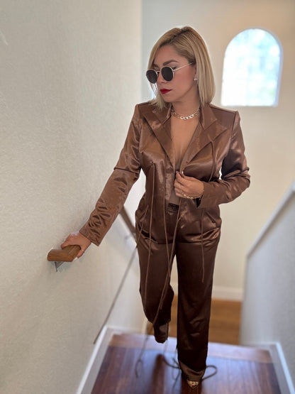 Bronze satin jumpsuit with long sleeves, drawstring waist, and tapered legs