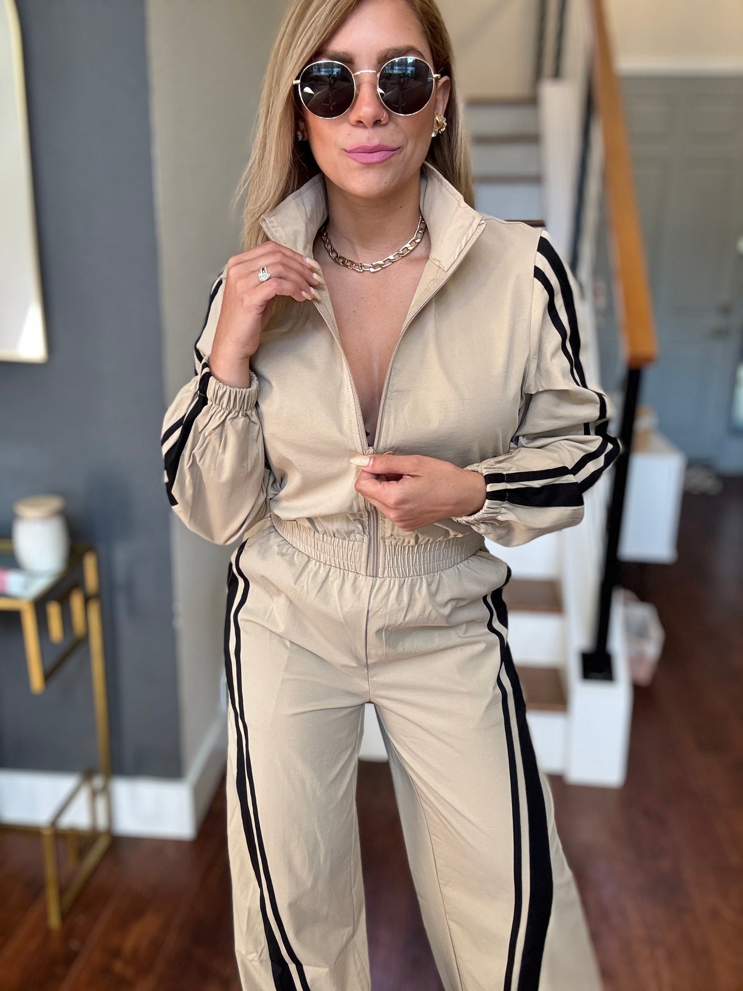 Bianca Fly jumpsuit in beige with hood, zip front, and ruched elastic waist with black stripes