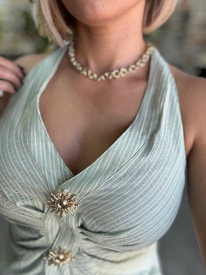 Light green halter top close-up: front knot with two gold floral buttons