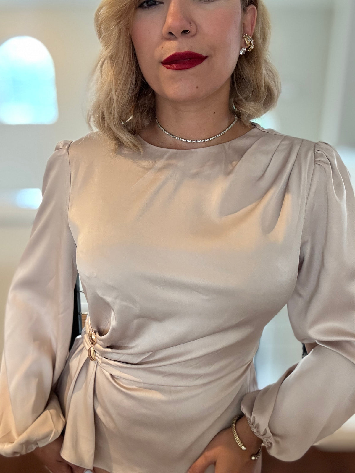 Beige satin top with puff sleeves, round neckline, and side waist knot