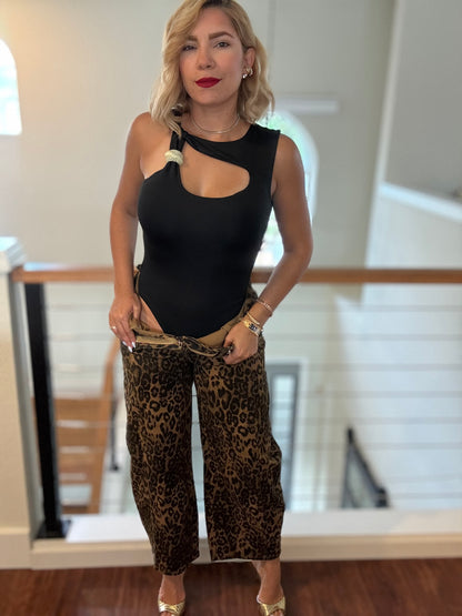 Black sleeveless bodysuit with chest keyhole cutout and pom-pom shoulder ties