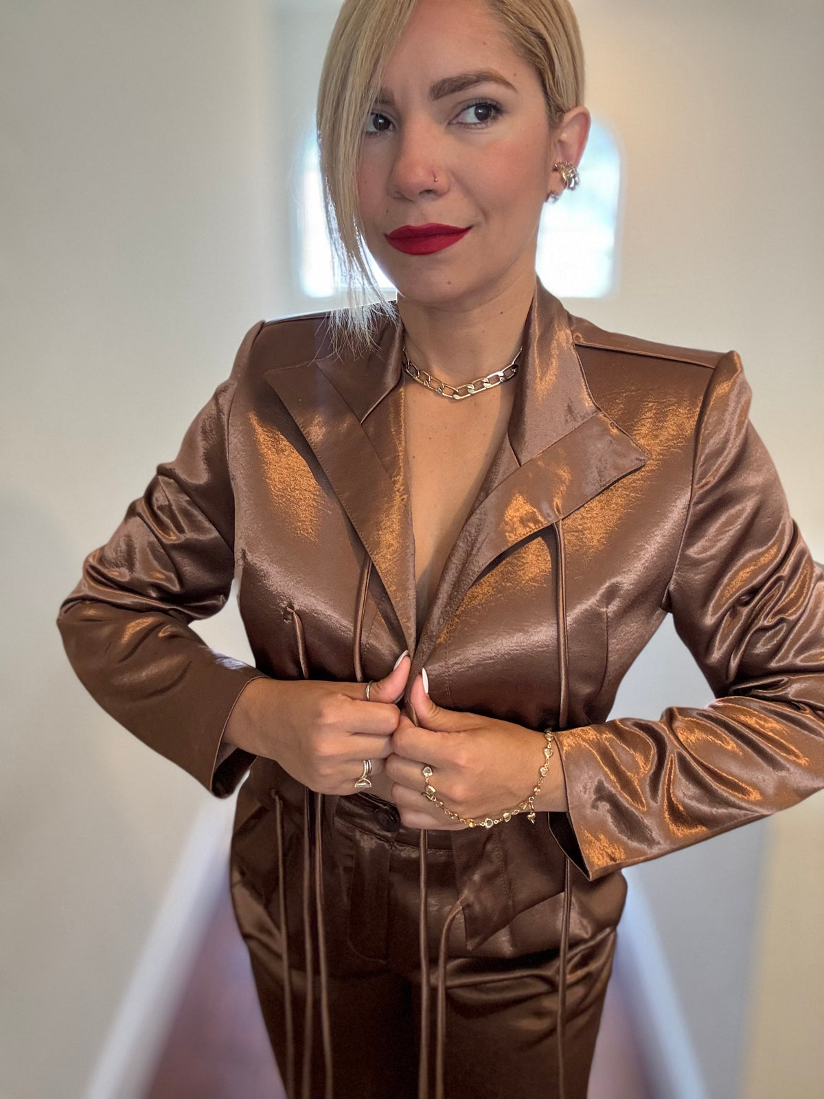 Bronze satin jumpsuit with deep V neckline and buttoned front with drawstring tie