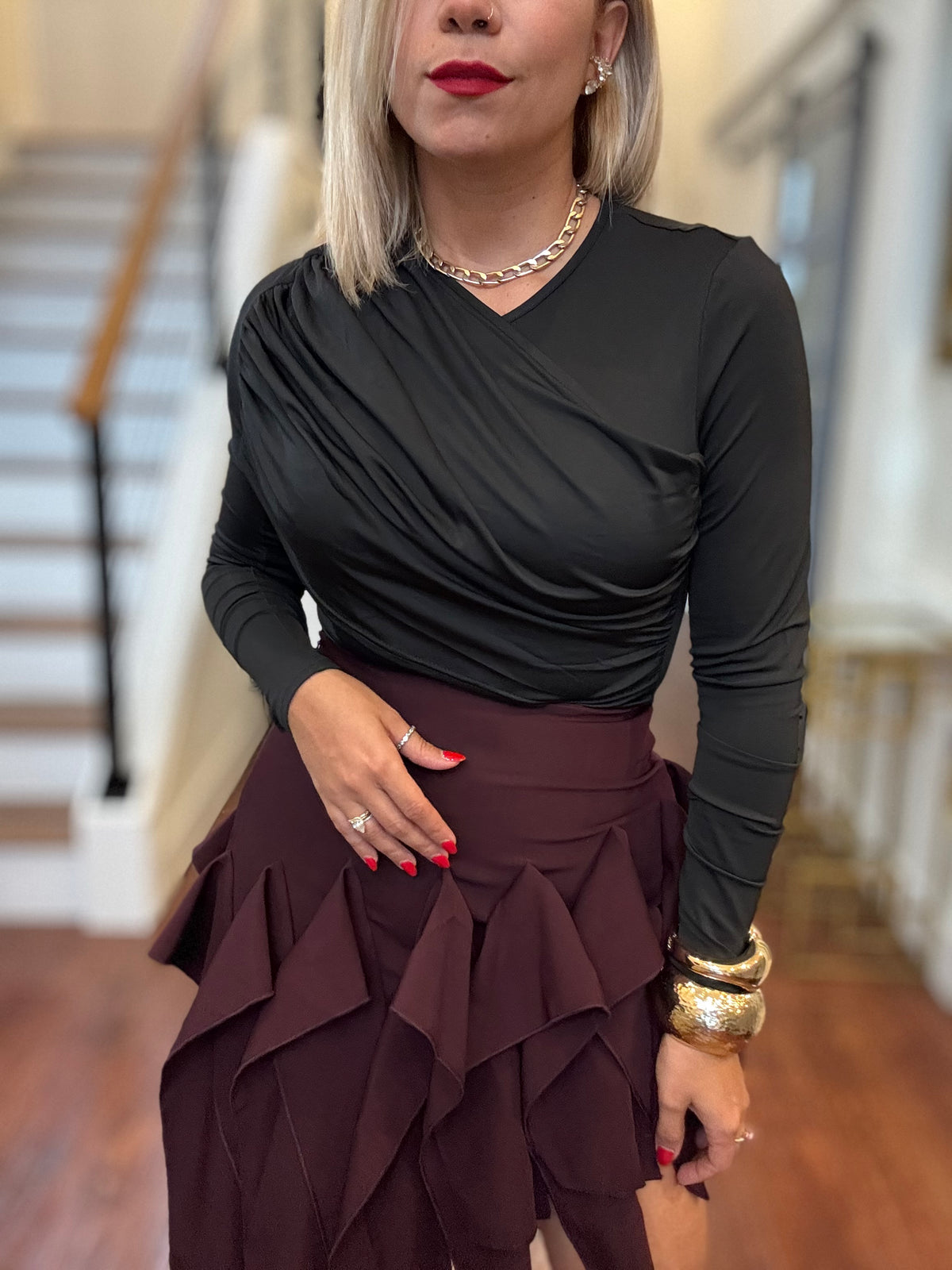 Black long-sleeve bodysuit with draped V-neck and side ruching detail