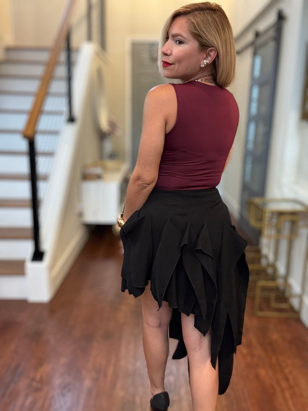 Black ruffle tier mini skirt with flared layered hem, side view