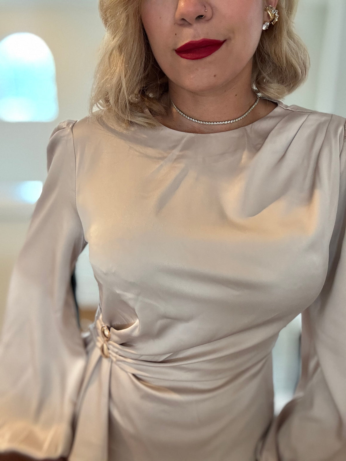 Beige satin top with puff sleeves, round neckline, and gathered waist knot detail