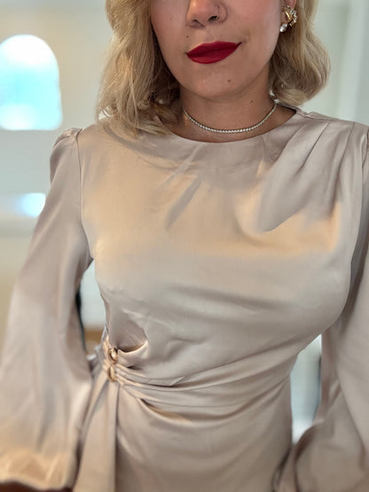 Beige satin top with puff sleeves, round neckline, and gathered waist knot detail