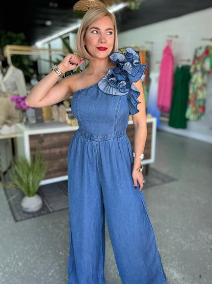 Blue denim jumpsuit with ruffled one-shoulder top and gathered waist, wide legs