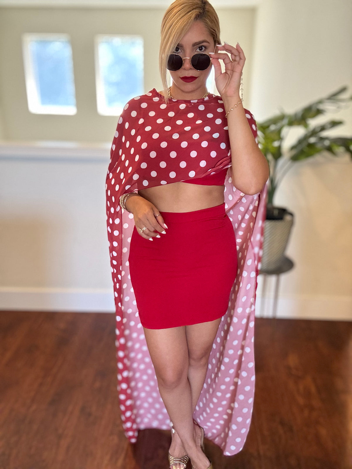 Red two-piece set with polka-dot sheer wrap, crop top and fitted mini skirt.