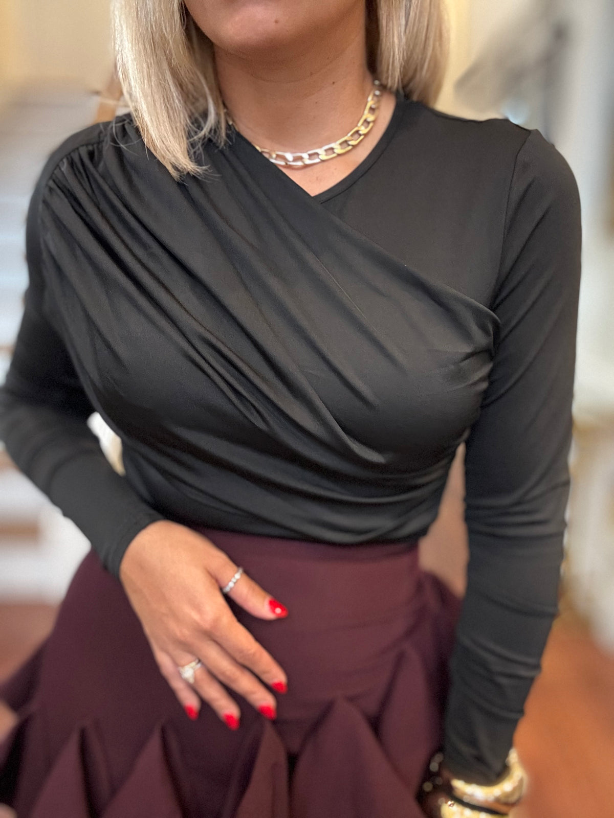 Close-up of black long-sleeve bodysuit with crossover V-neck ruching