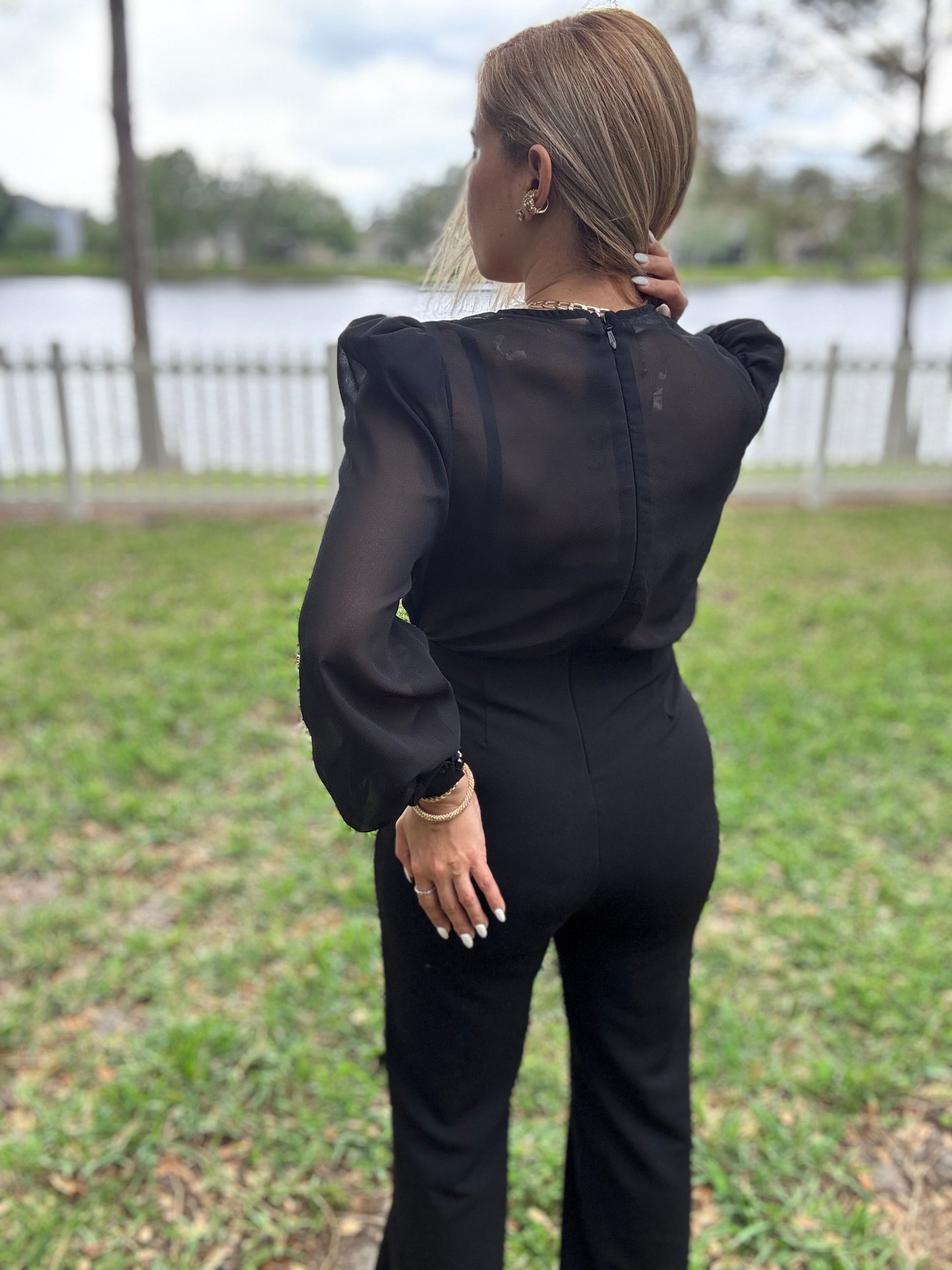 Black back view jumpsuit with puff sleeves and fitted straight legs