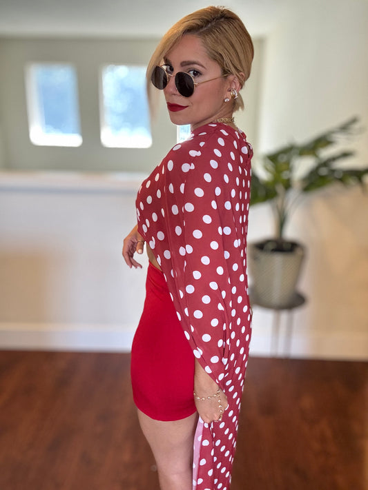 Red mini skirt with bandeau crop top and polka-dot sheer wrap over the shoulder.