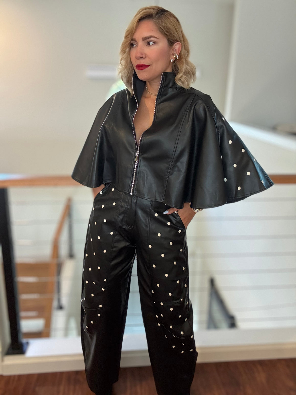 Black leather-style zip jacket with flared sleeves and studded wide-leg pants, full body