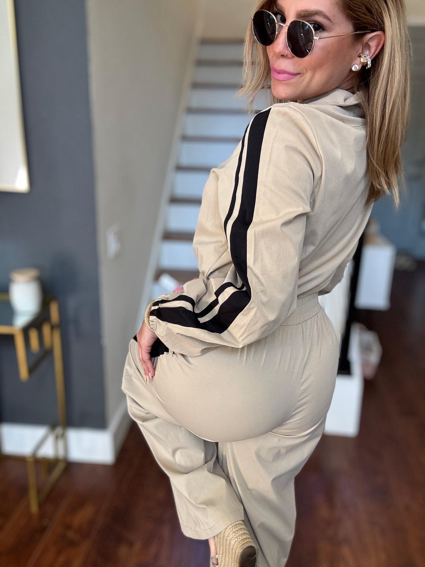 Beige jumpsuit with black striped trim