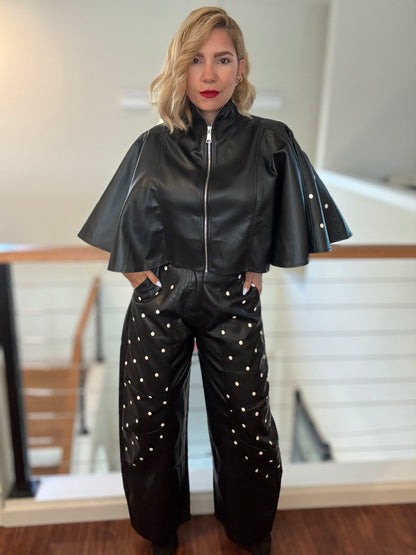 Black leather-style zip jacket with flared sleeves and studded wide-leg pants, front