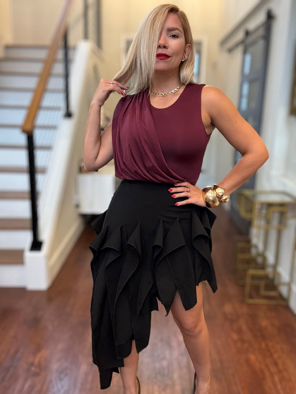 Burgundy sleeveless bodysuit and black ruffled skirt, 3/4 front view