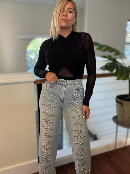 Black draped bodysuit with long sleeves and V neckline, sheer paneling at shoulders