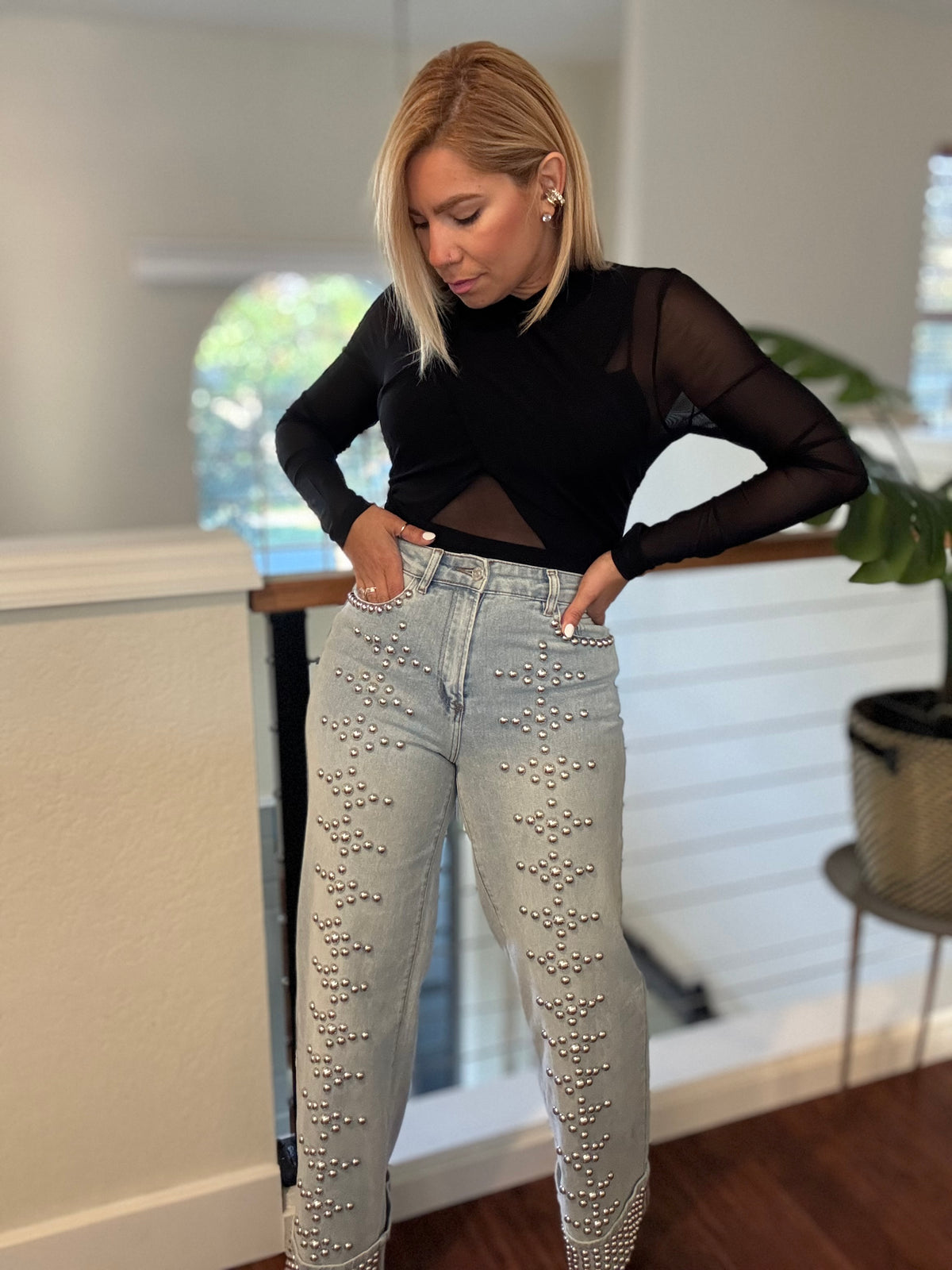 Light-wash studded jeans with silver-tone studs on front and back pockets
