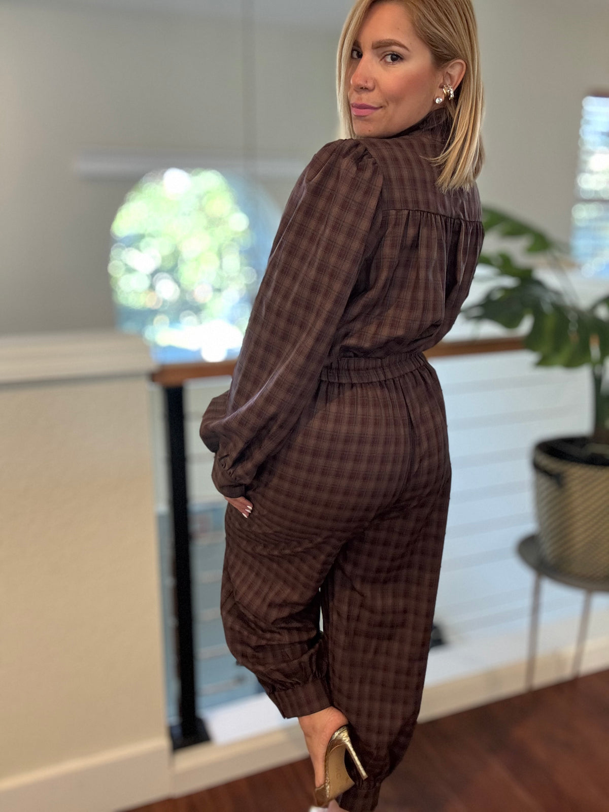 Brown plaid button-front top and jogger pants shown from a side angle